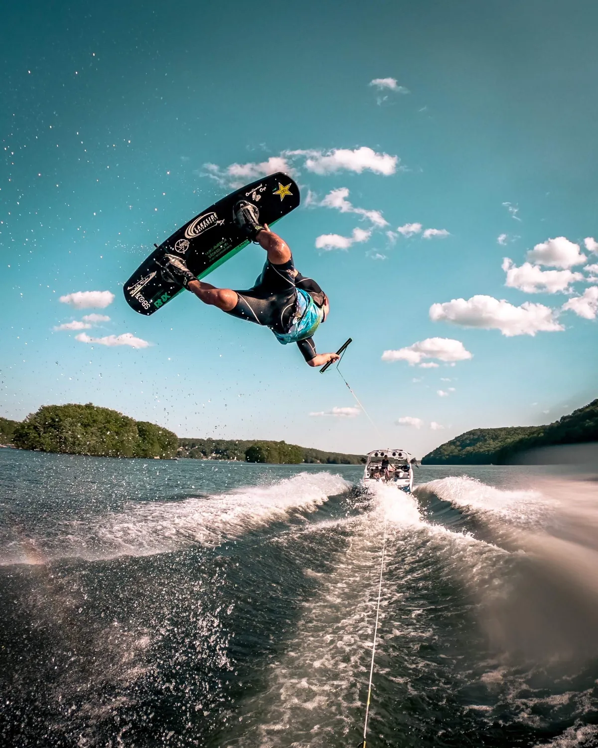 Lakeside Watersports instructor launching a wakeboard trick off the wake on Candlewood Lake